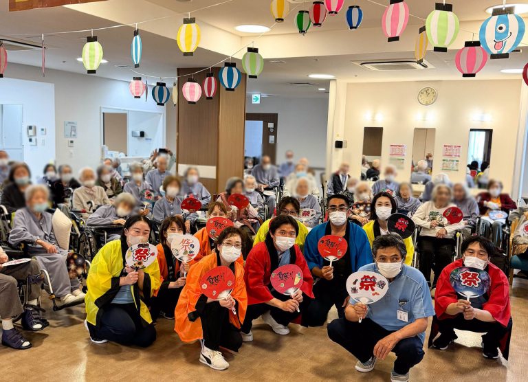 施設の大広間で職員と入居者が一緒にレクリエーション・行事を楽しむ風景